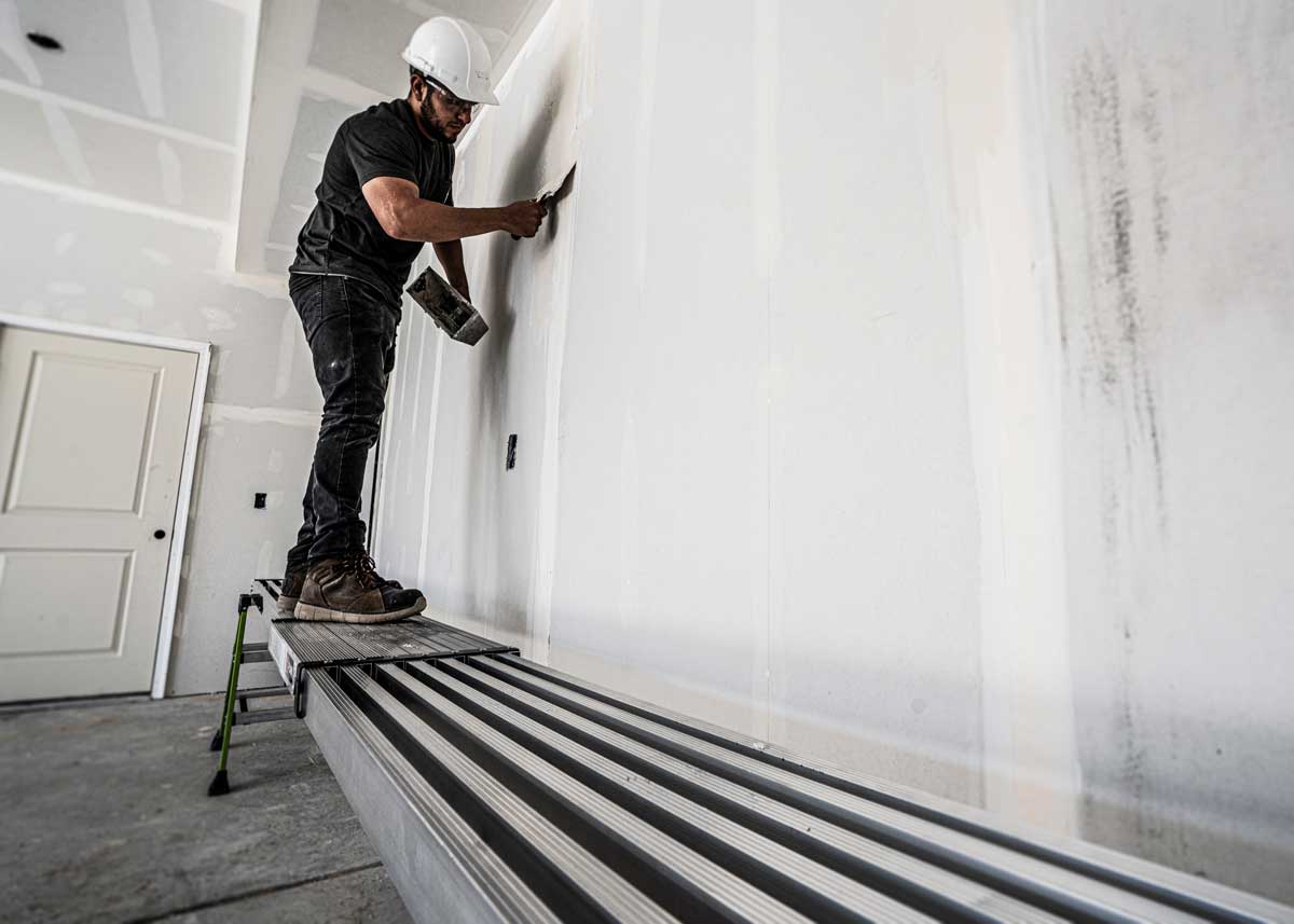A man painting a wall in a home