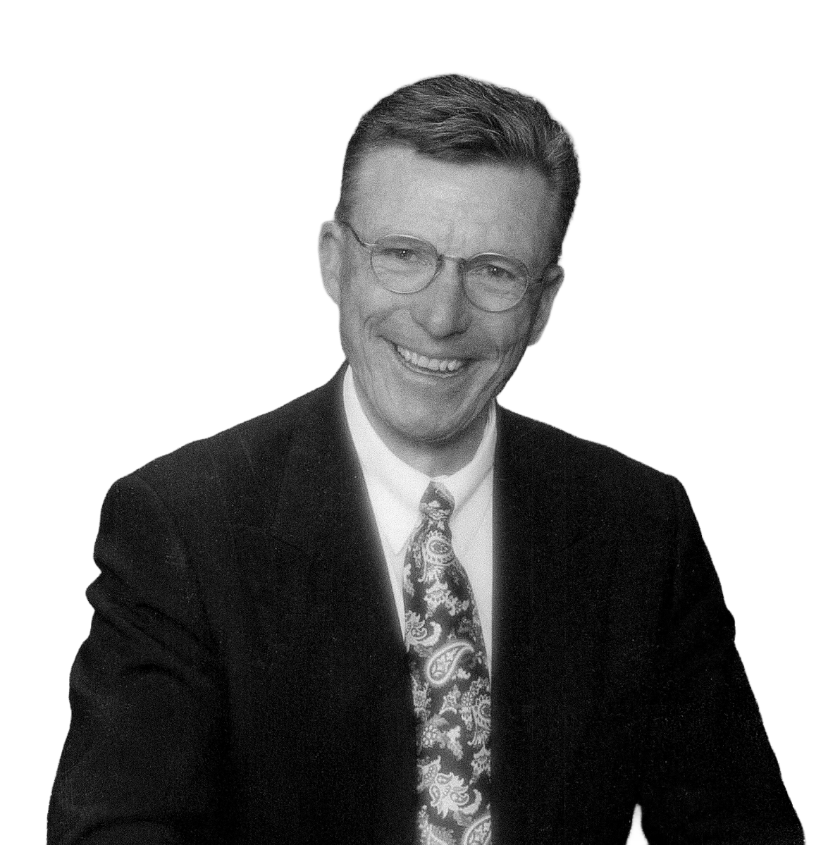 Black and white photo of a smiling man(Hal Wing) wearing glasses, a suit, and a patterned tie.