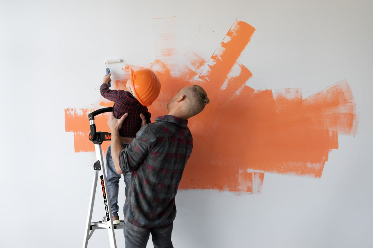 A Father and son painting a wall using a little giant XtraLite ladder